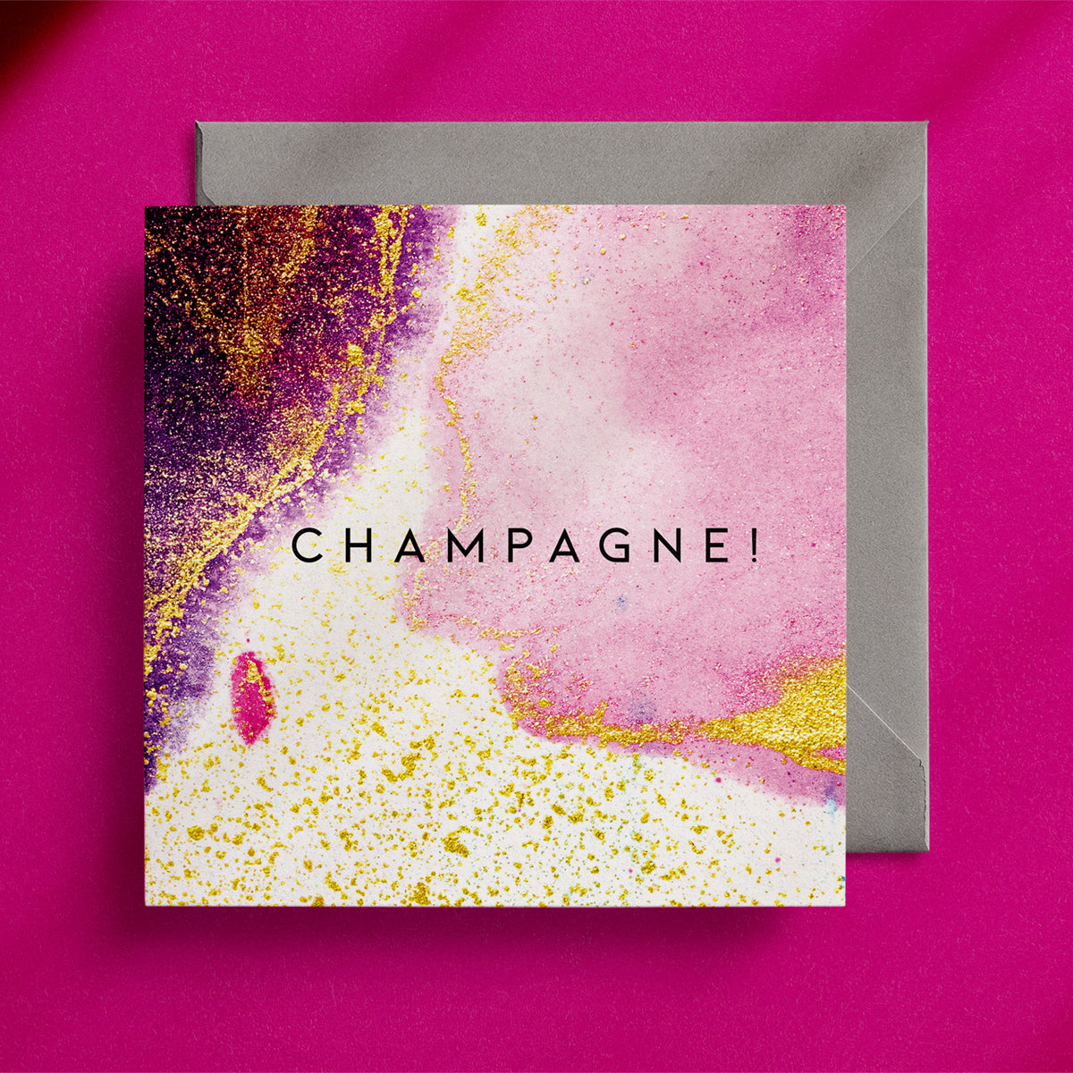Gold spattered, pink and purple abstract design on a square greeting card with the word "Champagne!" in the centre