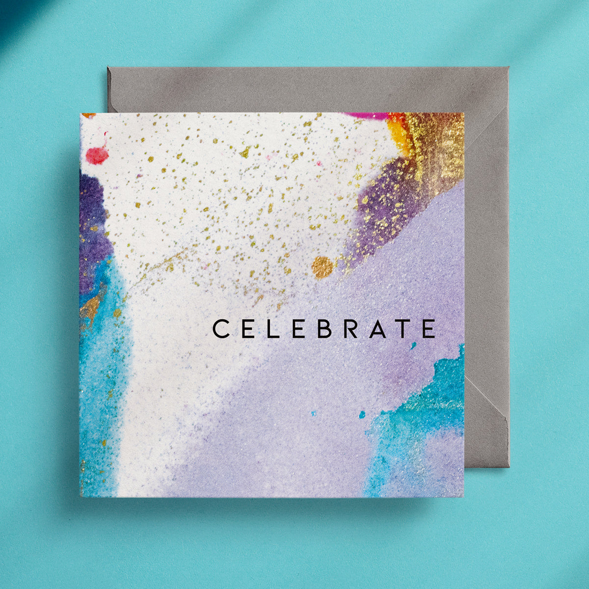 "Celebrate" greeting card with a blue and lilac abstract design with gold alcohol ink spattered over the top