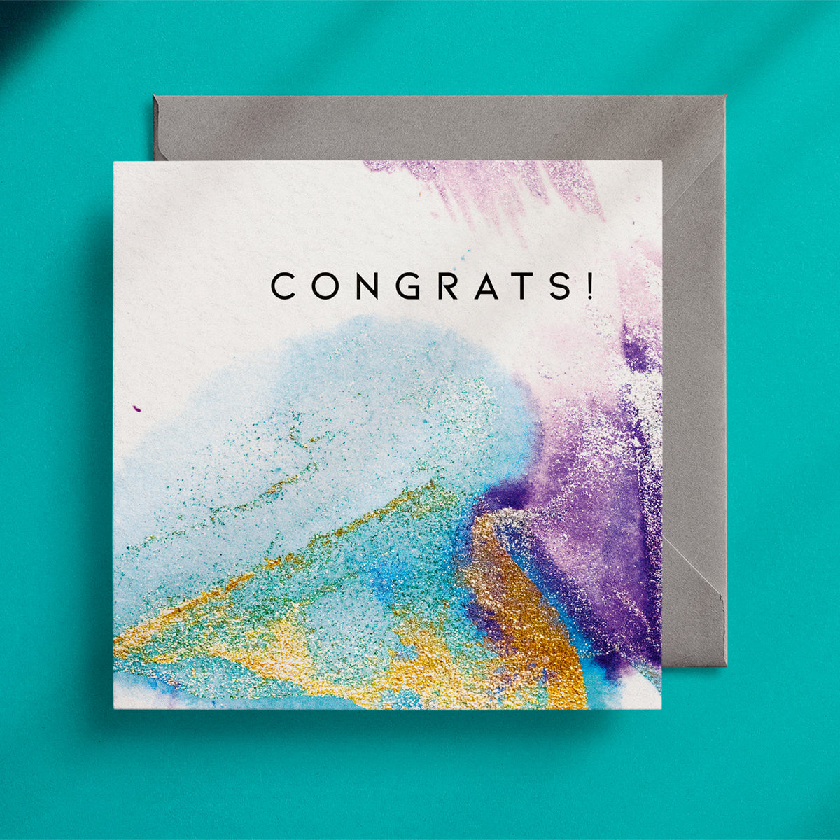"Congrats!" square greeting card with a turquoise, gold and purple ink design on a grey envelope