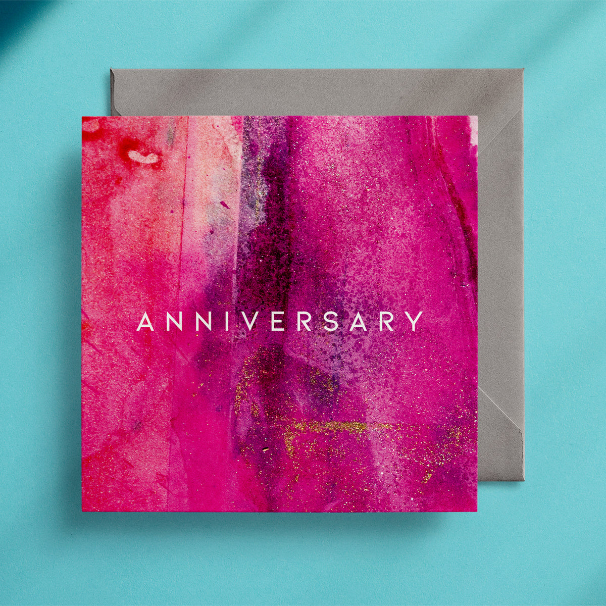 Hot pink Anniversary card with grey envelope on a turquoise background