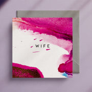 Pink and white, square greeting card with the caption "Wife" in the centre