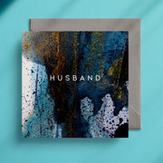 Dark blue and gold greeting card design with the caption "Husband" in the centre