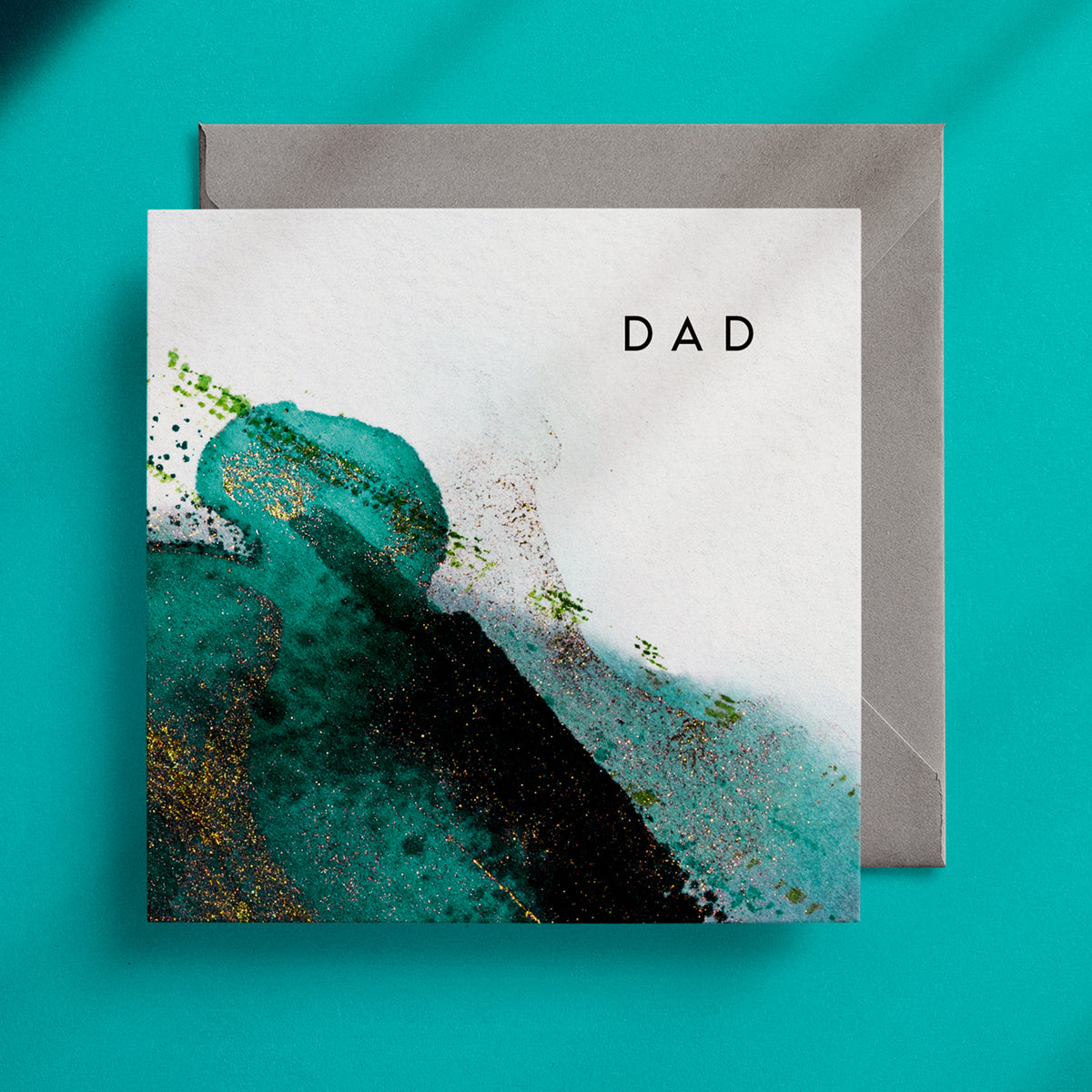 Rich green and gold abstract design on a square greeting card with the caption "Dad" in the top right corner