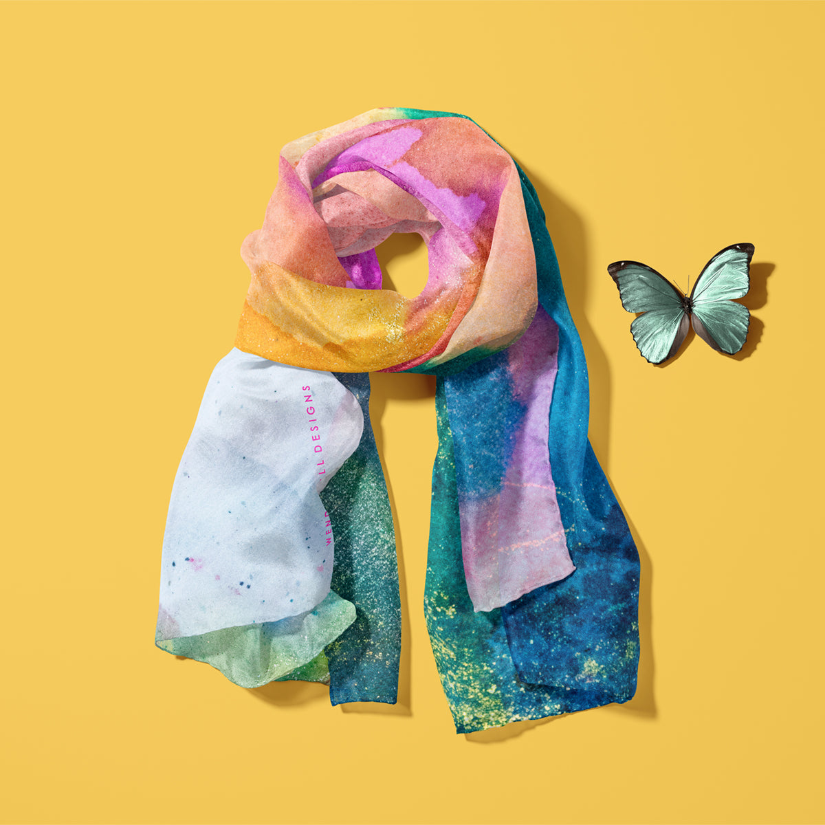 Vibrantly coloured 100% silk scarf in oranges, pinks and blue-greens laid on a yellow background
